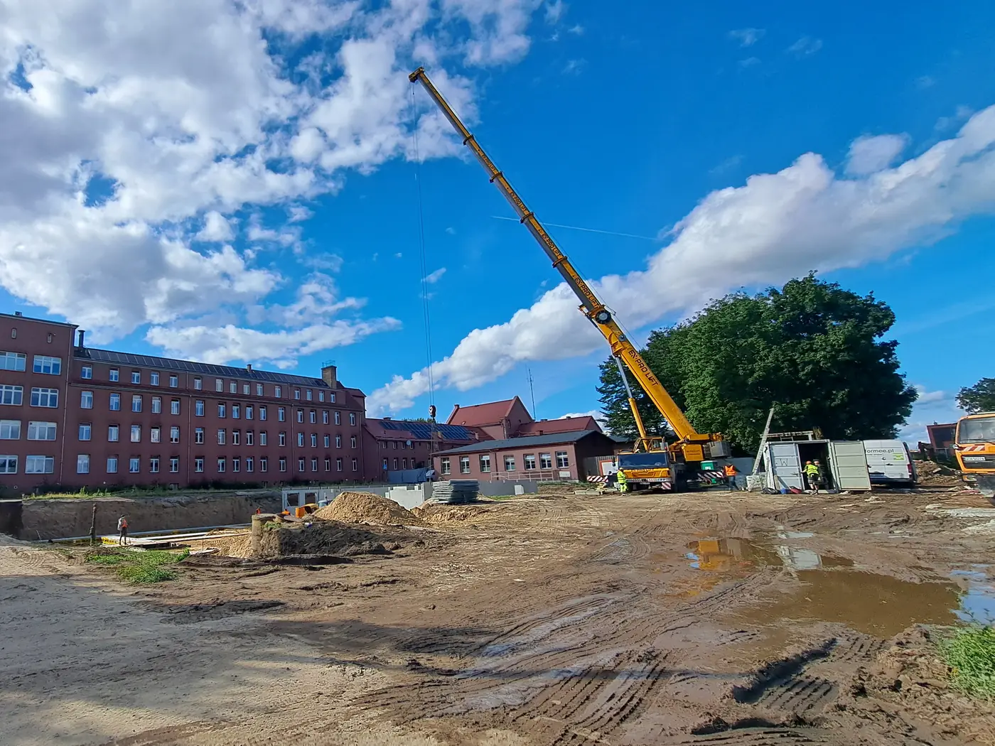 Początek budowy w Człuchowie — wykop pod nowy budynek, dźwig i samochody Formee na placu