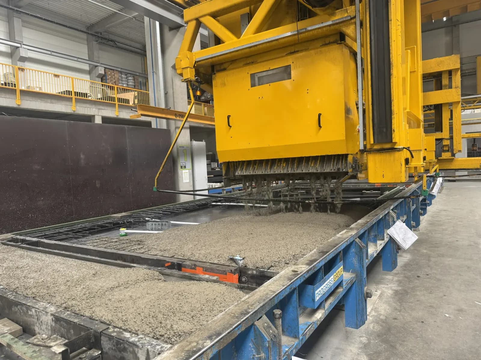 Udlægning af betonblanding over armeringen til et vægelement på et produktionsbord på Formees fabrik i Międzyrzecz
