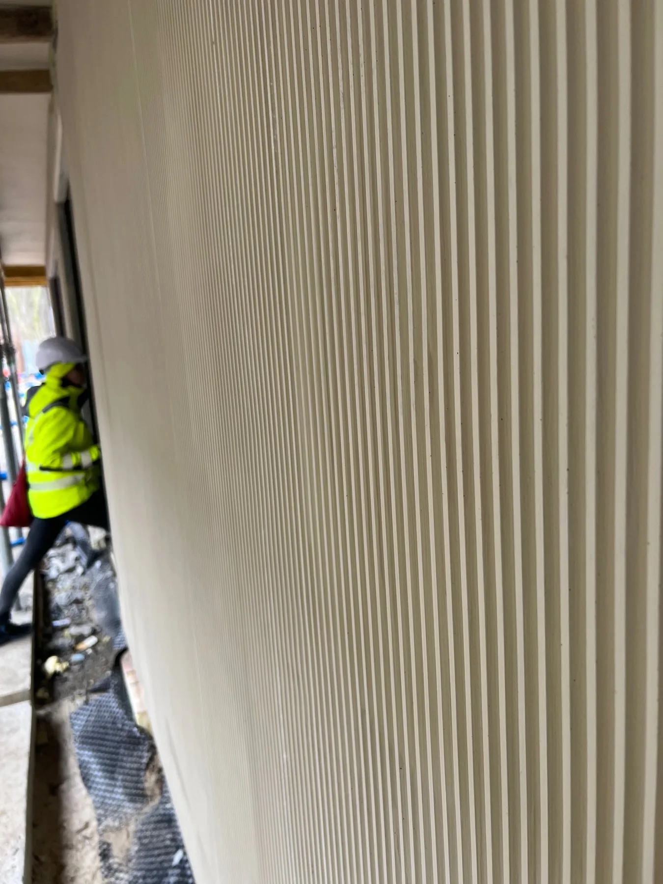Nahaufnahme der vertikal geriffelten Oberfläche der Betonvorsatzschale einer Sandwichwand