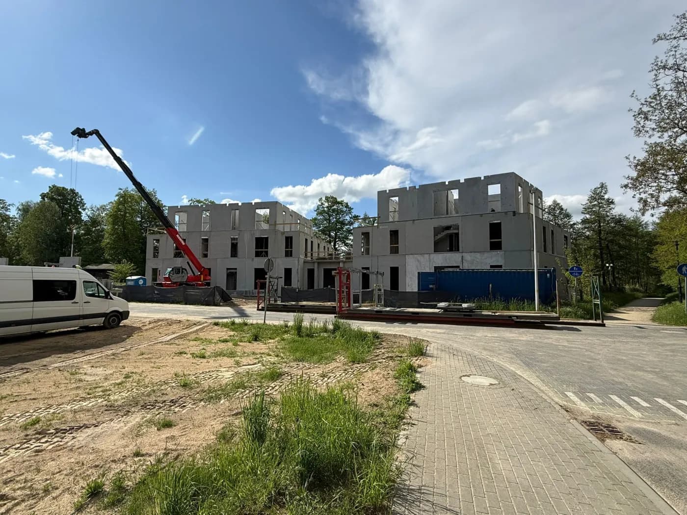 Dwa budynki pensjonatowe w Ośnie Lubuskim w trakcie montażu, z dźwigiem między obiektami